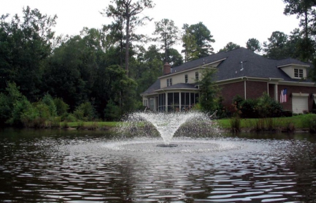 Aerating pond fountain near house